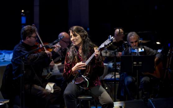 professor mindy cooper performs with an orchestra at a performance.