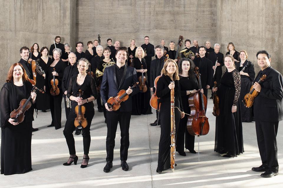 The Academy of St. Helen of the Fields poses for a group photo, holding violins and other stringed instruments.